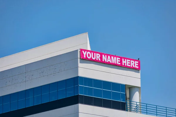 Your Name Here - large banner sign on vacant commercial building advertising the real estate, property, office for sale, rent or lease.