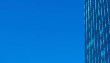 Genel modern ofis gökdeleninin tipik cam duvar cephesi, yüksek binalar. Mavi gökyüzü.