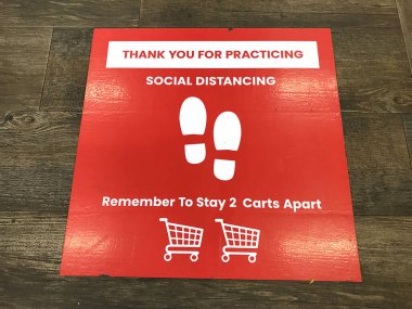 Social Distancing sign on floor of grocery store requesting customers to practice 6 feet distance using shopping cart as reference in order to prevent spread covid-19 - San Jose, CA, USA - May, 2020 clipart
