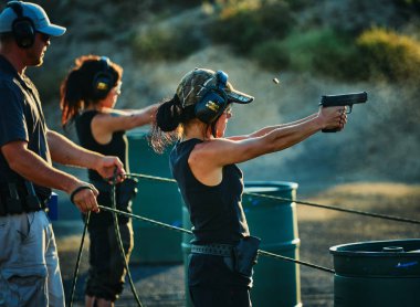 Young Woman Shooting a Firearm clipart