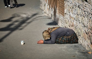 Dilenci kadın sokakta oturuyor. 