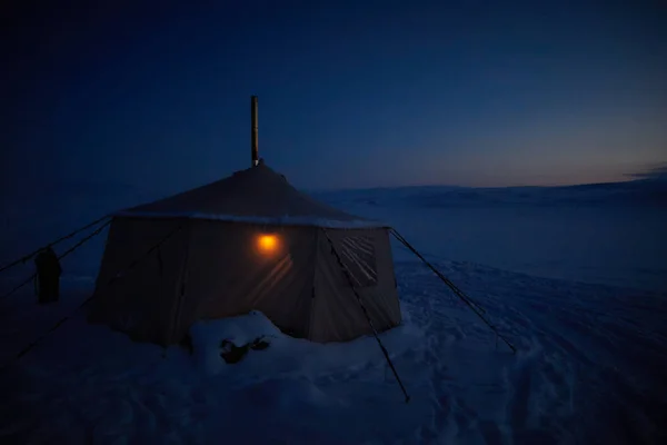 tent in the night winter landscape