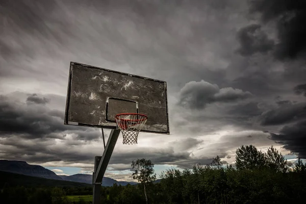 basketball basket against dramatic stormy sky