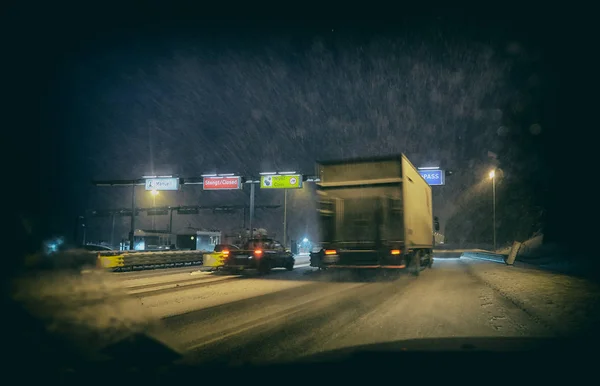 Cars at toll station on snowy evening