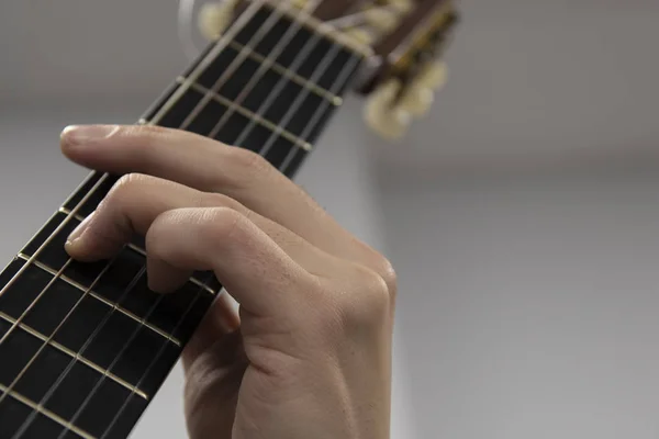 Guitars fingers on guitar neck in perspective