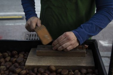 Sokak tezgahında kestane kıran adam