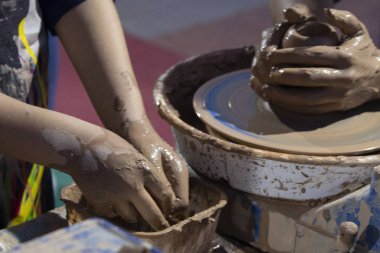 Kadın ve çocuk elleri kil çömlek yapıyor