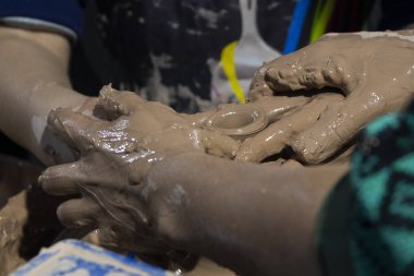 Kadın ve çocuk elleri kil çömlek yapıyor