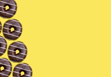 Sarı arka planda nefis jöleli donutlar, düz uzanmış. Metin için boşluk