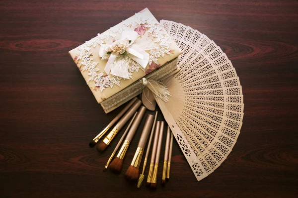 Vintage beautiful box and makeup brushes on wooden background