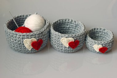 Üç gri örülmüş iç sepet farklı boyutlarda kalpler.