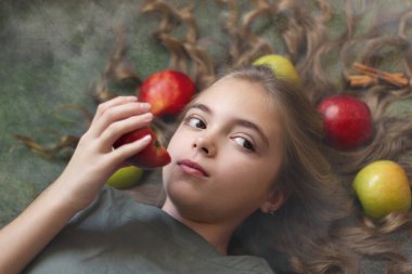 Saçında elmalar olan güzel bir kız resmi.