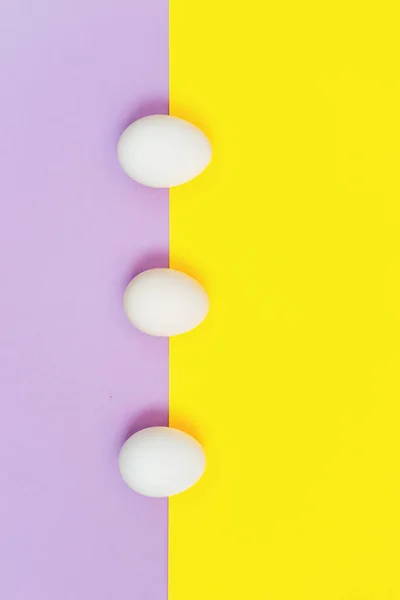 Leylak rengi ve sarı arka planda beyaz paskalya yumurtası — Stok fotoğraf