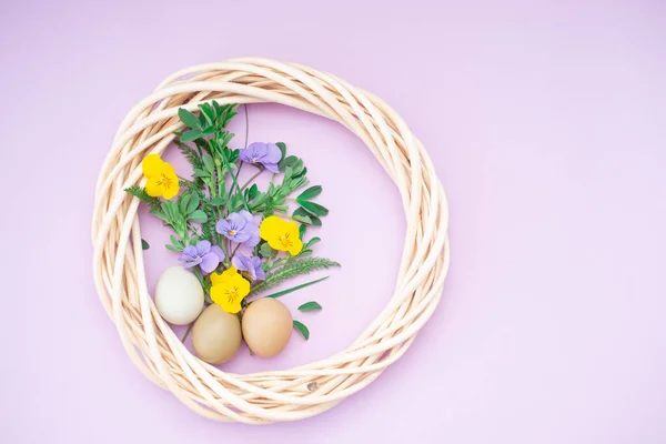 Букет з бузкових і жовтих квітів, великодні яйця на рожевому яскравому фоні з місцем для тексту — стокове фото