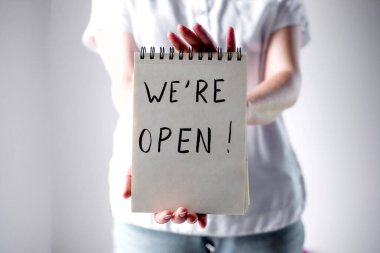 Kızın elinde üzerinde yazı olan bir defter var.