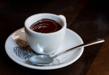 Tahta masada çay kaşığı ile küçük bir fincan sıcak çikolata