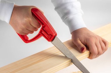 Bir Diy ev projesi için testereyle tahtayı kesen bir kadın. 