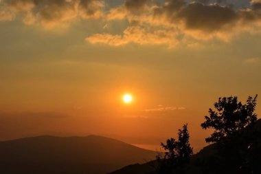 Bulutlu gökyüzü ile inanılmaz bir gün batımı. Turuncu ve kara bulutlu etkileyici bir gökyüzü.. 