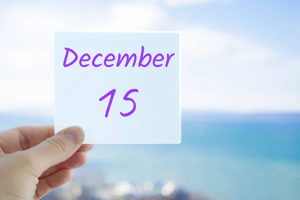 15 de diciembre. Pegatina de mano con texto del 15 de diciembre sobre el fondo borroso del mar y el cielo. Copia espacio para texto. Mes en concepto de calendario — Foto de Stock