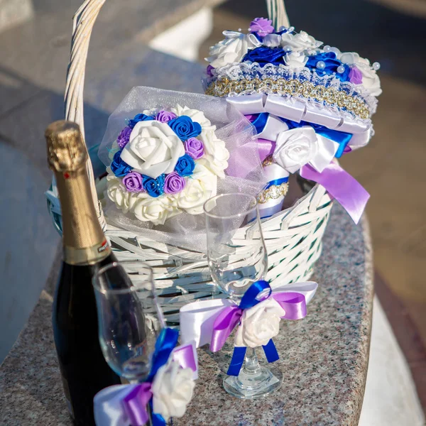 Wedding arrangement. Bridal bouquet. Bridal bouquet in a basket with a bottle of champagne and glasses. Wedding design concept. Wedding composition