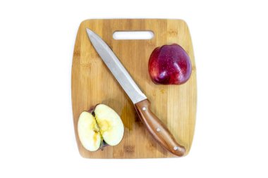 Mutfak bıçağıyla dilimlenmiş yeşil elma ahşap bir tahtanın üzerinde yatıyor. Organik meyve. Sağlıklı bir yaşam tarzı. Tatlı meyve. Doğal vejetaryen sağlıklı yiyecekler. Beyaz arkaplan.