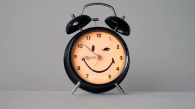 Sarı ve siyah tasarımlı alarm saati tik tak eder ve göz kırpar