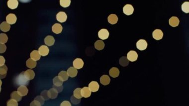Altın Bokeh Işıkları Kara Arkaplan üzerine odaklanır. Yanıp sönen ışık sızıntıları