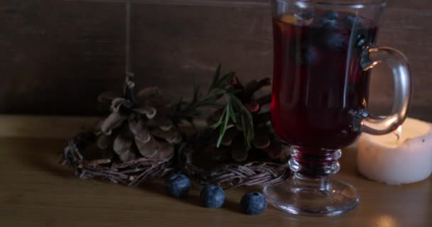 Irsk kaffeglass med brennende lys av gløgg, blåbær, trebakgrunn – stockvideo