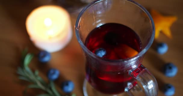 Blueberry rushes into a Irish coffee glass with mulled wine on a wood background — Stock Video