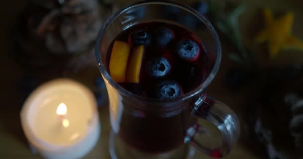 Swing focus on hot mulled wine, candle on a wood background. — Stock Video