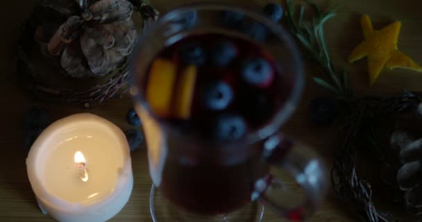 Swing focus on hot mulled wine, candle on a wood background. — Stock Video