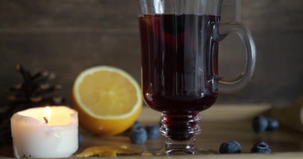 Light on, light off candle near hot mulled wine on a wood background. — Stock Video
