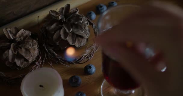 Tänd, tänd ljus nära varm glögg vin på en trä bakgrund. — Stockvideo