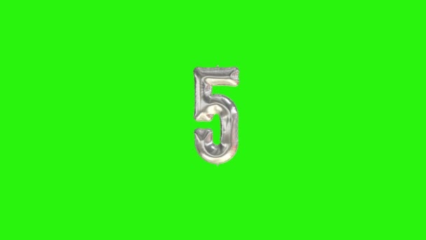 Номер 5, пятый год празднования серебряного шара из фольги, плавающего на зеленом — стоковое видео