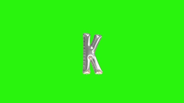 Zilverkleurige letter K. Zilverkleurige folie helium ballon alfabet drijvend op groen scherm — Stockvideo
