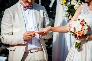 Düğün töreni, damat gelinin eline nikah yüzüğü takar. Yeni evli çift.