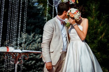 Düğün töreni, gelin ve damat öpüşür ve bir buket çiçekle kaplanır.