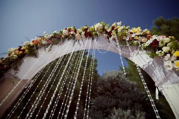 空に対して新鮮な花と明るいスタイリッシュな美しい結婚式のアーチ — ストック写真