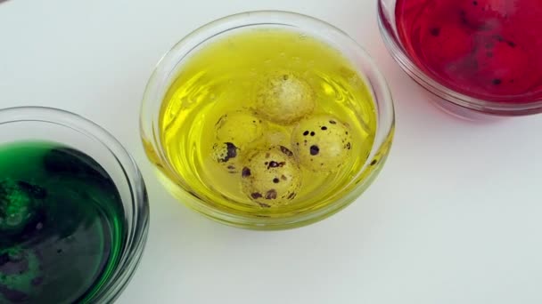 Três copos transparentes com solução amarela, vermelha e verde para pintar ovos de Páscoa — Vídeo de Stock