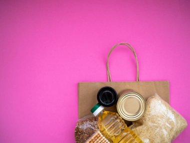 Pembe zemin üzerinde yiyecek malzemeleri olan el işi paket, fotokopi alanı olan üst görünüm