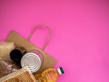 Pembe zemin üzerinde yiyecek malzemeleri olan el işi paket, fotokopi alanı olan üst görünüm