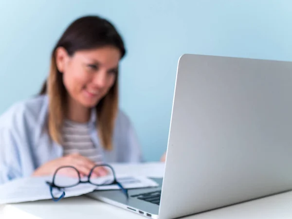 Дистанционное обучение онлайн. Женщина учится с ноутбуком, смотрит вебинар — стоковое фото