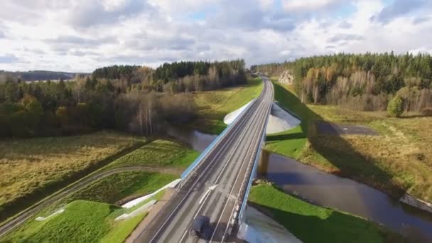 Hermosa vista aérea del puente de carretera sobre el río rodeado de bosque — Vídeos de Stock