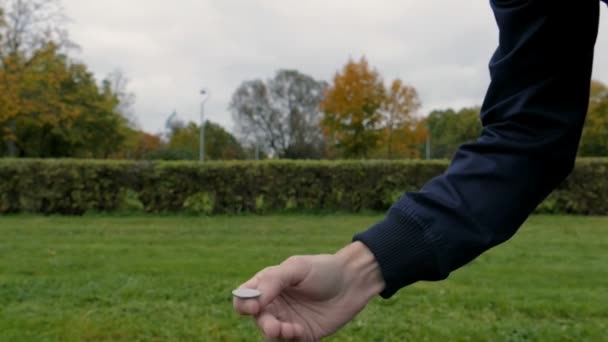 Hand van de mens gooit een muntstuk in slow motion — Stockvideo