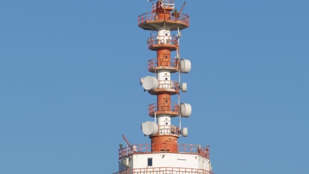 Radiotelecommunications antenna with repeaters and other equipment on blue sky background — Stock Video