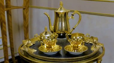 çay seti altın tepsi üzerinde yapılmış. İki kupalar, şeker kaseler, çaydanlık ve kaşık oluşur