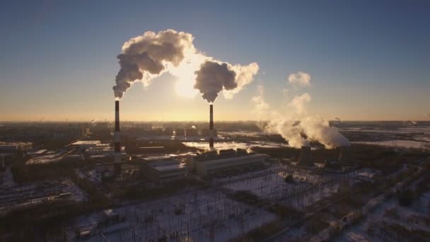 Курение дымоход электростанции на фоне заката в зимний период. Вид с воздуха — стоковое видео
