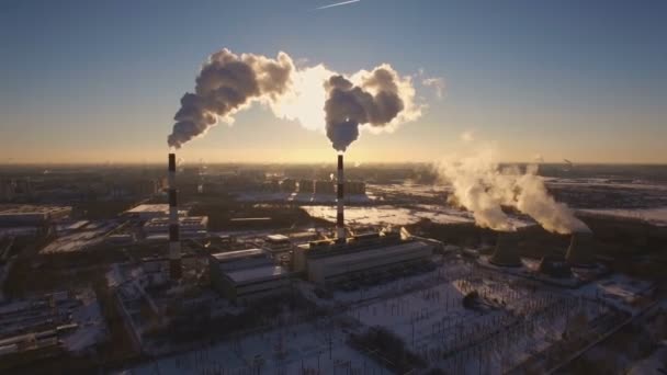 冬の夕日を背景に喫煙煙突の発電所。航空写真ビュー — ストック動画