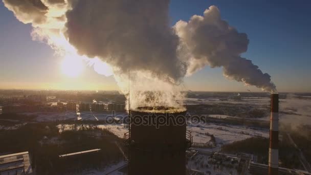 冬の夕日を背景に喫煙煙突の発電所。航空写真ビュー — ストック動画