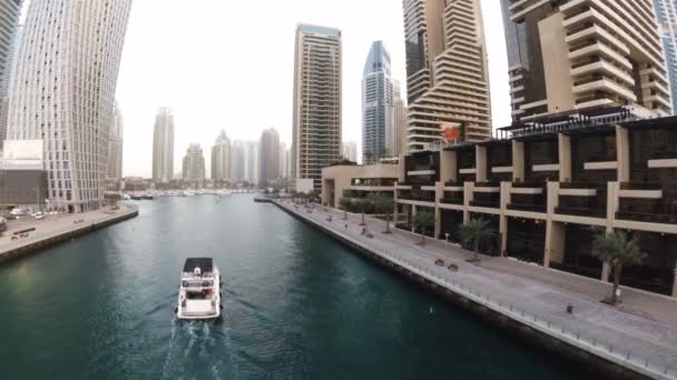 Vattnet Dubai Marina med en strandpromenad där promenader turister och marine kanalen där seglar båtar — Stockvideo